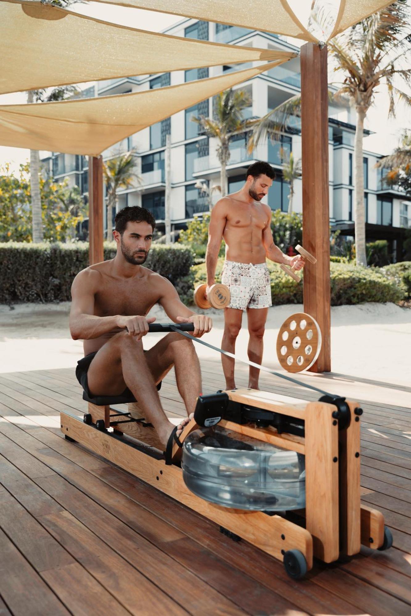 凯撒宫殿蓝水酒店 迪拜 外观 照片 A man using a water-resistance rowing machine